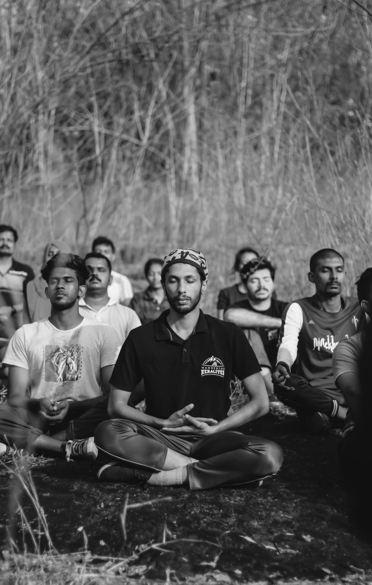 group of men be conscious and present together meditating in front of long grass
